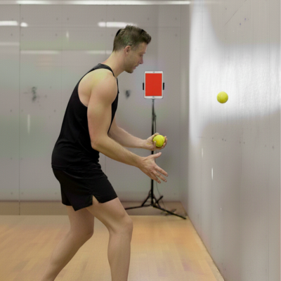 Athlete doing reaction drill indoors with Balls against a wall